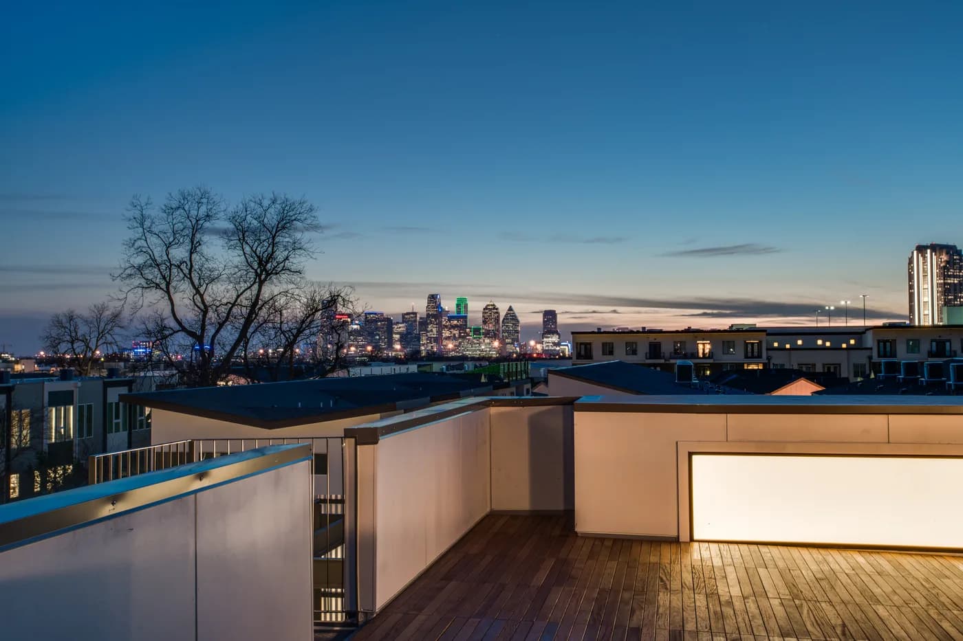 Crestfield Place rooftop deck at dusk with the Dallas skyline