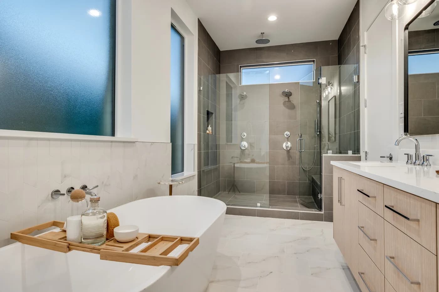 Bath with a freestanding tub and frameless glass shower