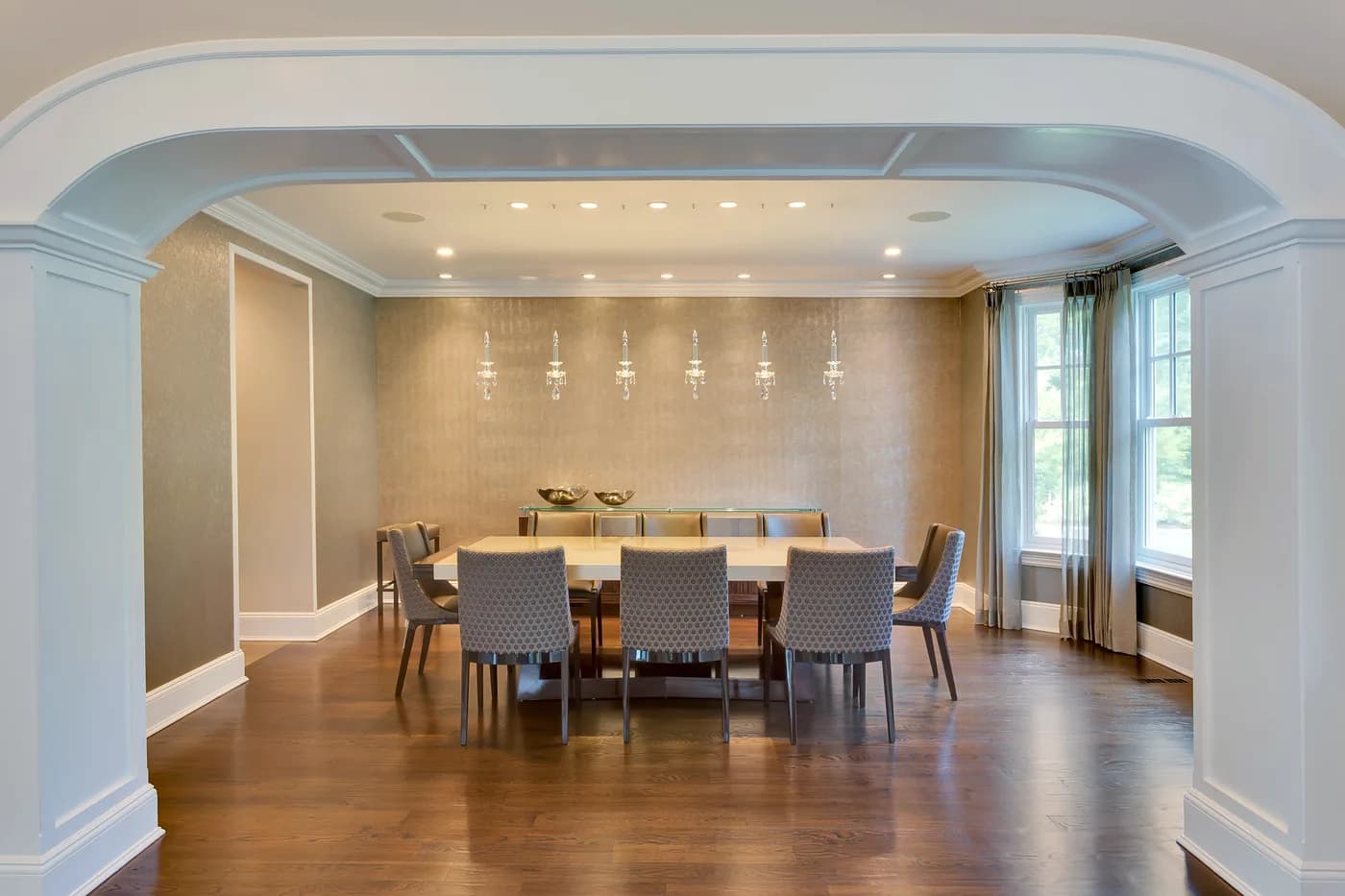 Formal dining room seen through an arched opening